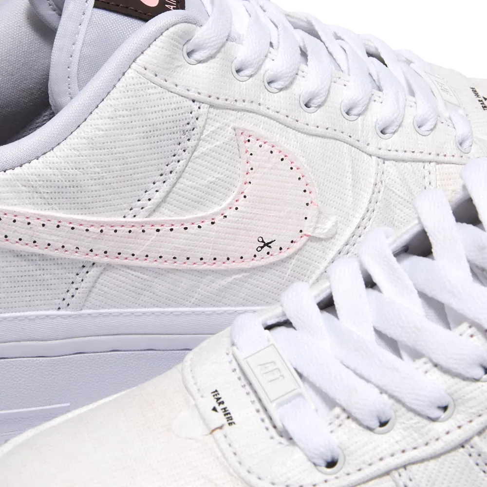 Detalhe do cabedal de um tênis branco com costura pontilhada rosa